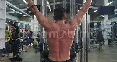 大型健身班运动员努力工作，使他的肌肉更用力做背部锻炼，从背部拍摄视频